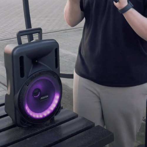 Picture of the Fenton FT08LED MK2 8" Portable PA System playing music outside beside a person for scale